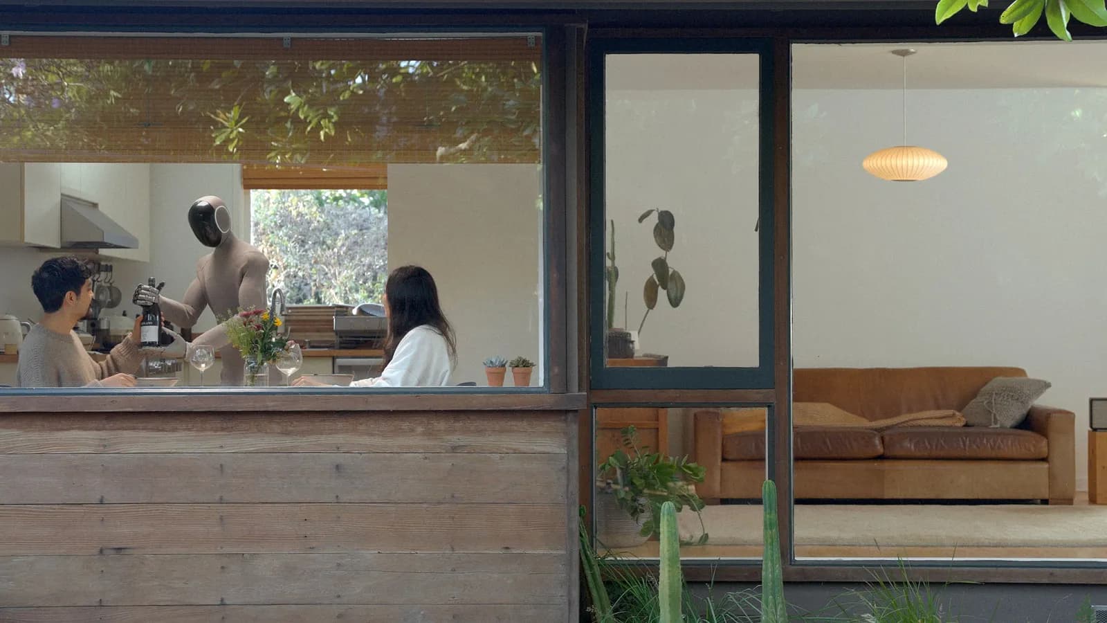 NEO home robot handling a wine bottle for two people in a kitchen