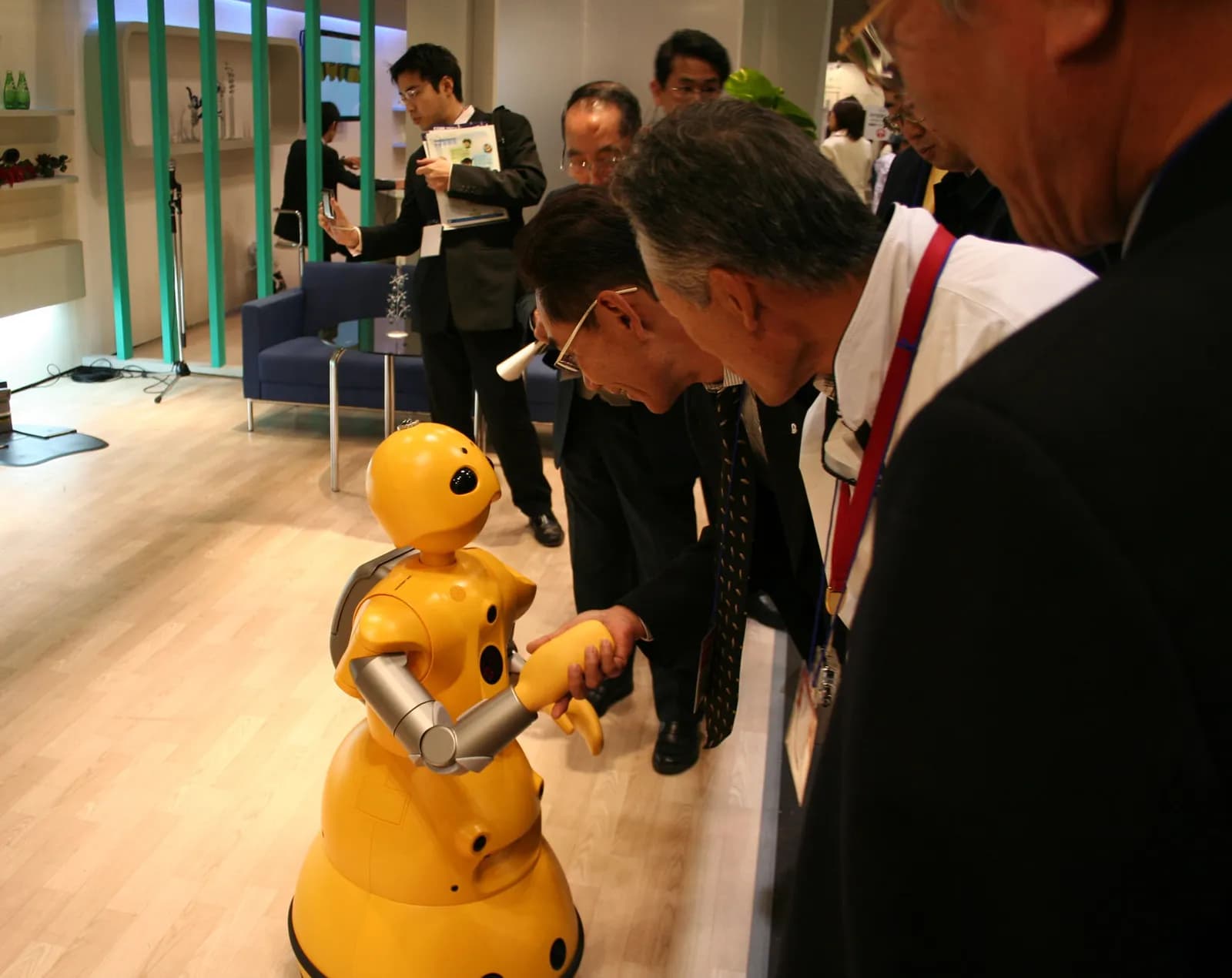 Wakamaru robot shaking hands with a person at a robot exhibition