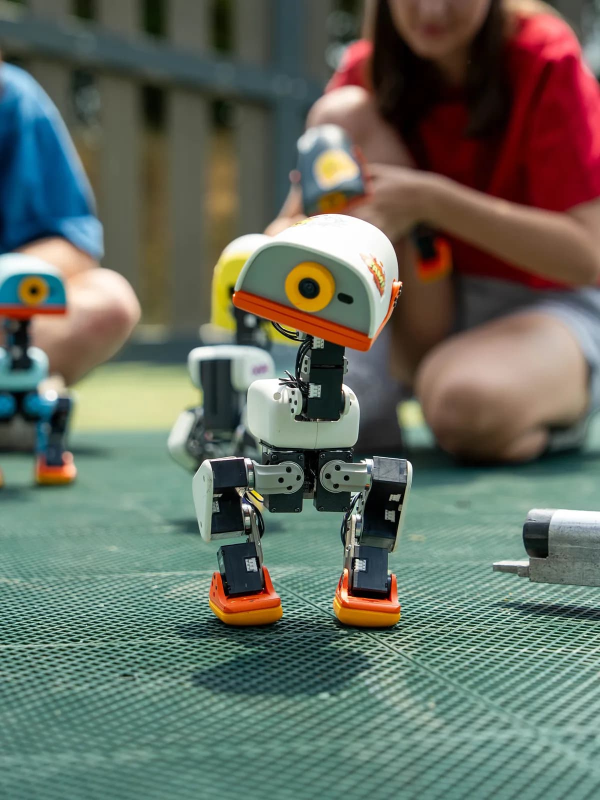 Microduck walking across a green games table surrounded by people
