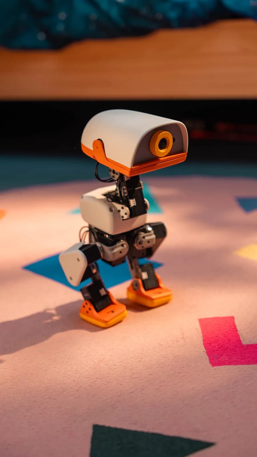 Microduck standing on a pink rug in a child's playroom